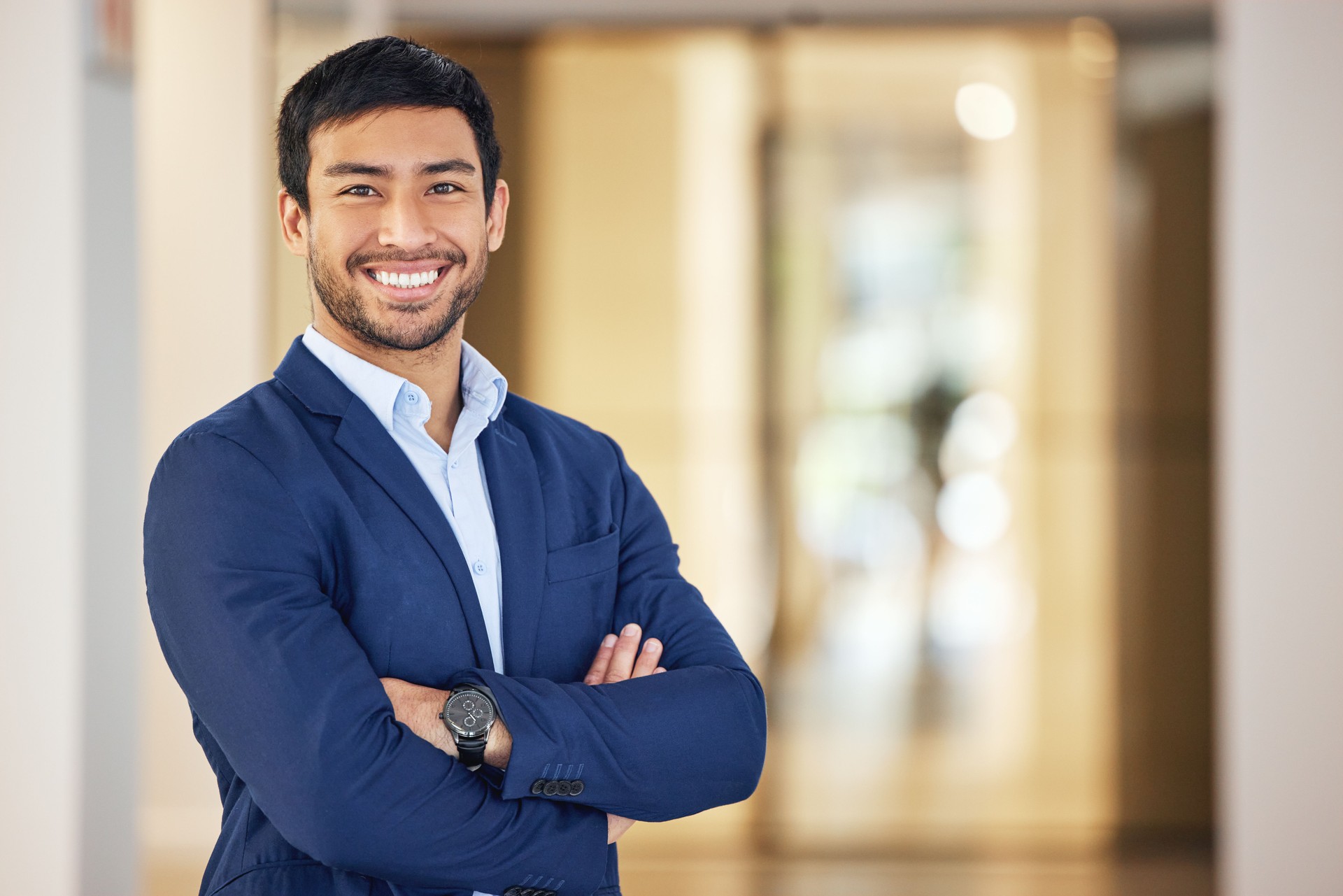 Portrait of a confident young businessman standing with his arms crossed in an office